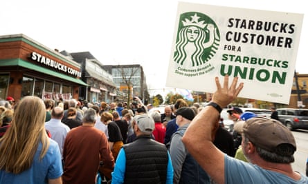 People gather outside a Starbucks store while singer Billy Bragg performs for striking Starbucks Workers United Union members in Buffalo, New York, on October 12.
