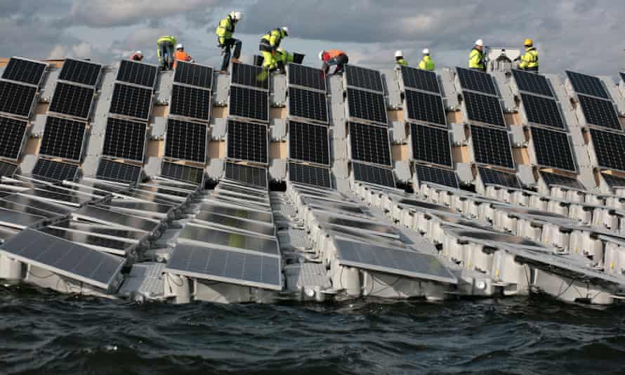 Crews install panels that form the world’s largest floating solar power array in the Queen Elizabeth II reservoir near Heathrow.