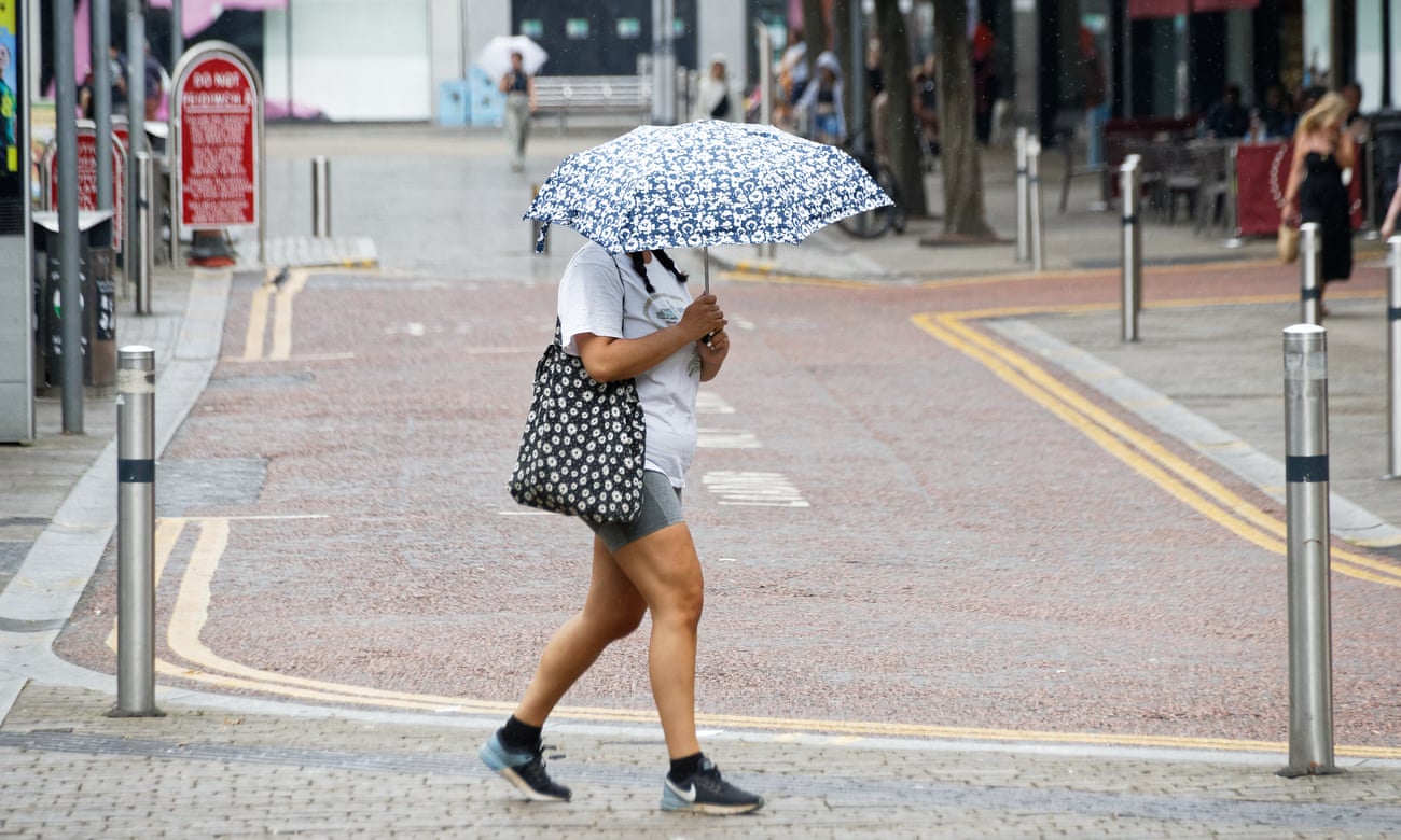 A woman walks with an umbrella during a spell of rain in Oxford Street, in the city centre of Swansea, Wales
