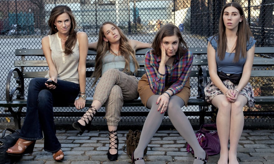 Lena Dunham sitting on a bench with her Girls co-stars.
