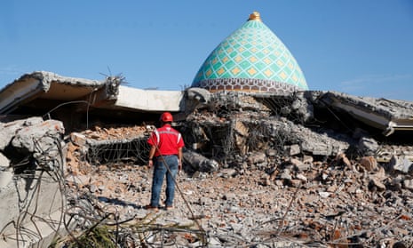 A rescue worker looks at the remains of a collapsed mosque in Lombok after an earthquake
