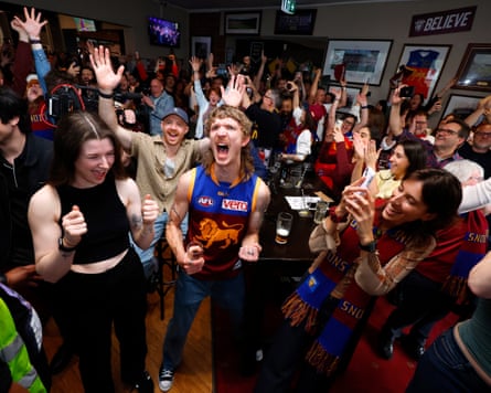 Brisbane Lions fans watching the game live at the Royal Derby Hotel in Fitzroy celebrate their teams win during the AFL grand final