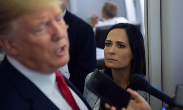 Stephanie Grisham listens as Donald Trump speaks to reporters aboard Air Force One on 7 August 2019.