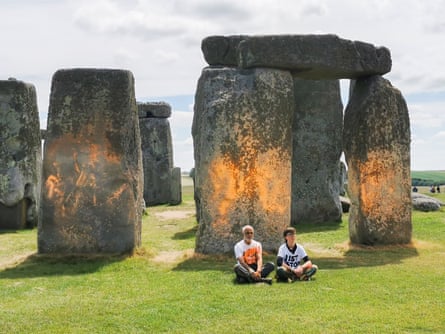 Two people sit in front of orange-sprayed stones