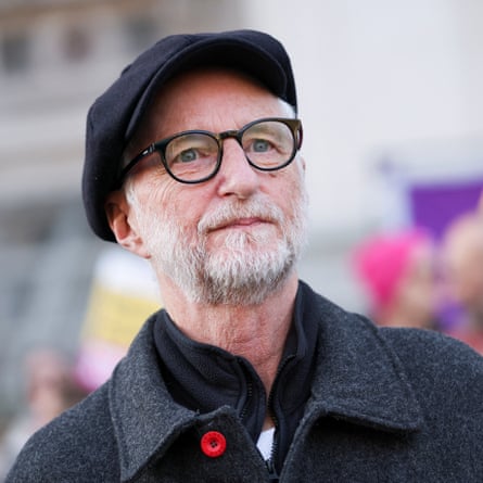 Man in black flat cap and glasses with black overcoat