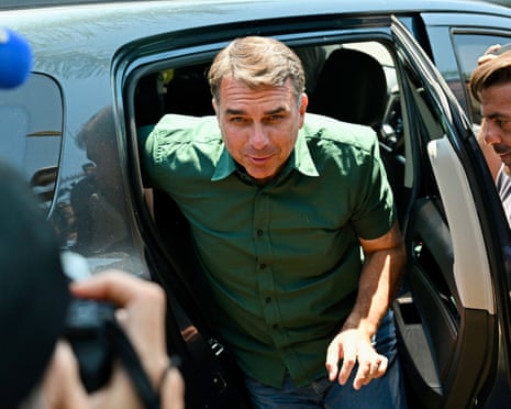 Flávio Bolsonaro getting out of a car.