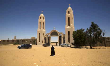 A priest walks in front of the Saint Samuel monastery in Maghagha.