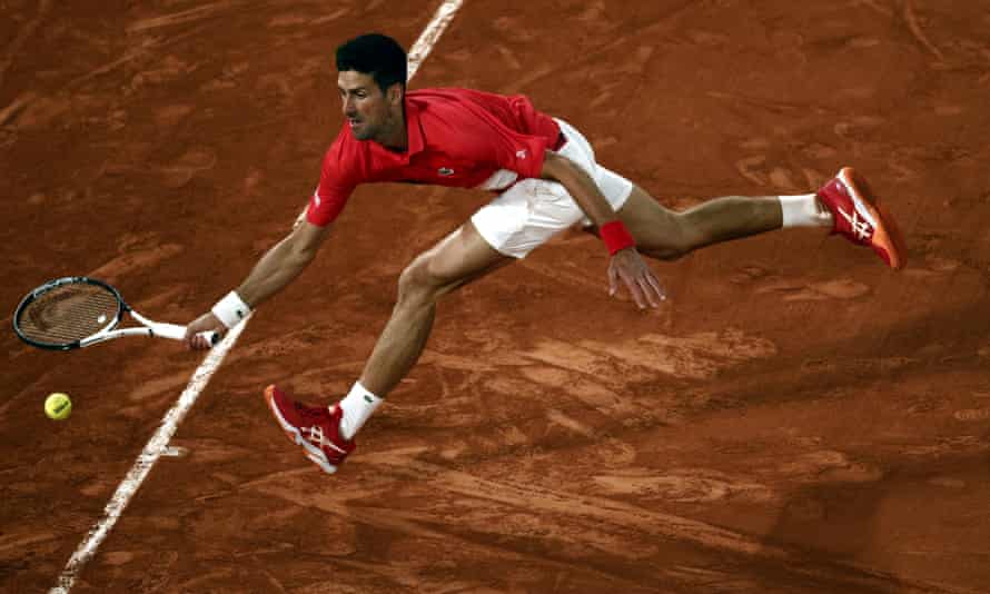 Novak Djokovic stretches as he readies to play a return to Rafael Nadal.