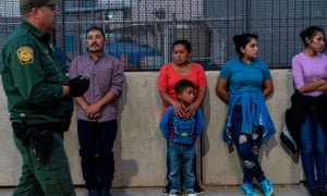 Migrants, mostly from Central America, wait to board a van which will take them to a processing center, in El Paso, Texas, on 16 May.