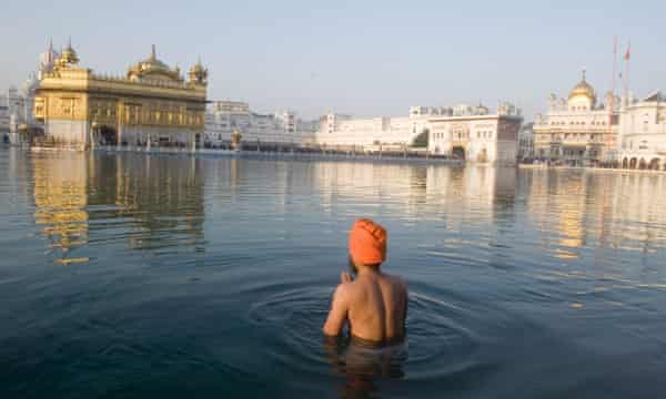 Un hombre sij en el estanque sagrado del Templo Dorado, en Amritsar