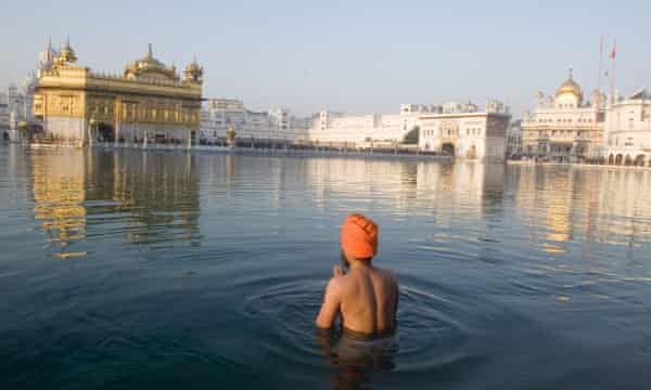 Un uomo Sikh nello stagno sacro del Tempio d'Oro, Amritsar