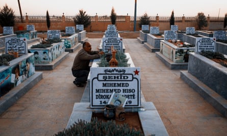 A man visits the grave of his son inside a cemetery for fallen SDF soldiers near the town of Hasakah in north-east Syria.