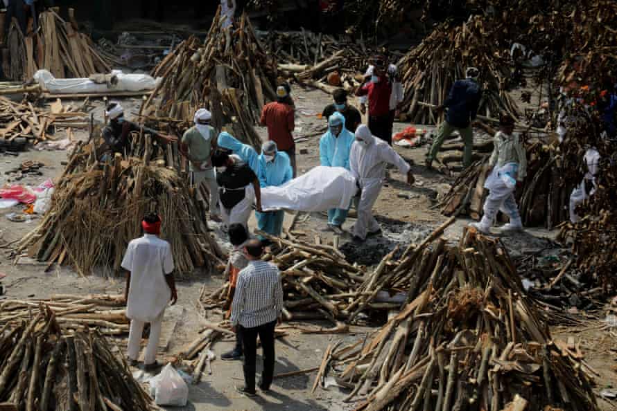 People wearing PPE carry the body of a family member who died of Covid-19, at Ghazipur cremation ground in New Delhi.