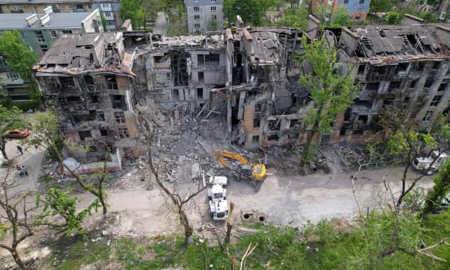 Russian authorities clear a damaged residential building in Mariupol.
