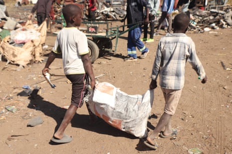 Boys struggle to make a living by delivering scrap metal to a yard in Hopley near Zimbabwe’s capital, Harare
