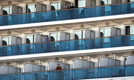Passengers in masks standing on balconies outside cabins on the Diamond Princess cruise ship