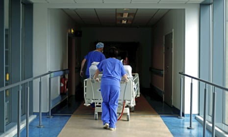 Medical staff transfer a patient through a corridor in hospital