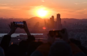 Seoul, South Korea. People enjoy the last sunset of the year on a viewing deck at Namsan Tower.