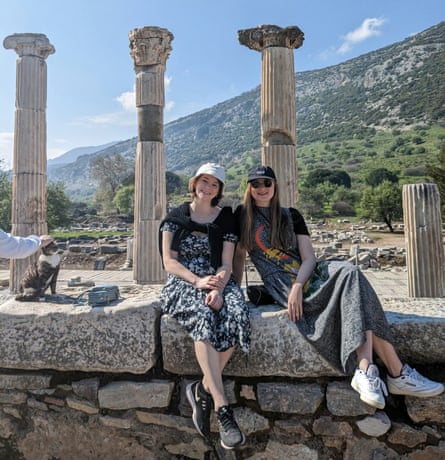 Two young women sitting on ruins