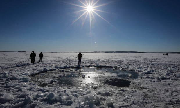 Žmonės stovi toje vietoje, kur, kaip manoma, 2013 metais virš Rusijos Čeliabinsko miesto sprogęs meteoras.