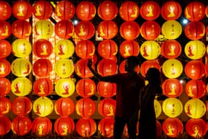 A couple take a selfie in front of lanterns decoration