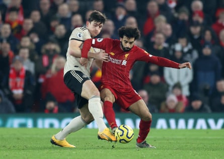Manchester United’s Harry Maguire attempts to contain the threat of Liverpool’s Mohamed Salah.
