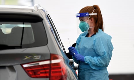 healthcare worker rakes a swab from someone in a car