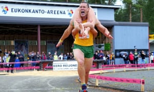 Vytautas Kirkliauskas of Lithuania carries his wife Neringa Kirkliauskiene, as they compete during the Wife Carrying World Championships in Sonkajarvi, Finland on 6 July 2019.