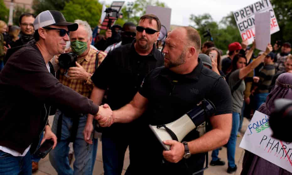 Conspiracy theorist Alex Jones shakes hands during a ‘Reopen America’ rally in Austin, Texas, on Saturday.