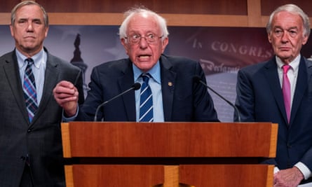 Senator Bernie Sanders, flanked by Senators Jeff Merkley, left, and Ed Markey, urges Joe Biden to invoke the 14th amendment.