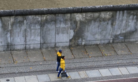 People walk past a remaining section of the Berlin Wall