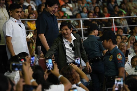 Philippine President Ferdinand Marcos Jr. greets residents as he arrives to attend a mass to commemorate the 10th anniversary of Super Typhoon Haiyan