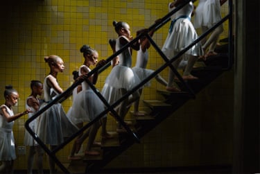 Young dancers in tutus from the Joburg Ballet School climb a staircase