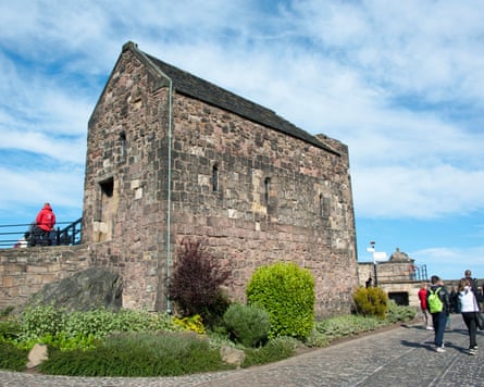 Visitors walk outside St Margaret’s Chapel, Edinburgh Castle, Edinburgh, Scotland, UK, on a blue sky day