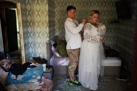 Liudmyla Ryzhak and her fiance, Leonid, get dressed for their wedding in their damaged apartment after a Russian missile and drone attack in Kyiv on Tuesday.