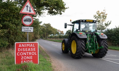 A tractor passes a sign marking the border of an Avian Influenza Prevention Zone near Eccles in Norfolk.