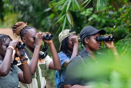 Four women looking through binoculars. 