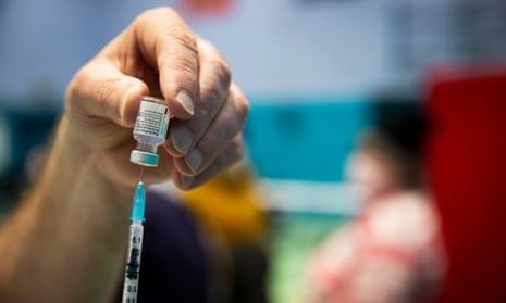 Vaccine dose being drawn into syringe from vial