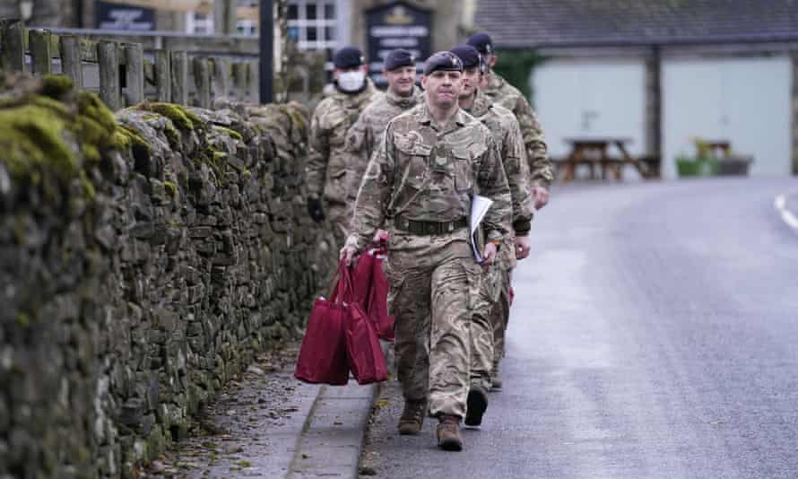 Members of the armed forces carry care packs to hand to residents in St John’s Chapel in County Durham