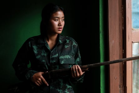 A teenager holding a rifle at a window