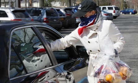 A teacher gives food to people in cars in North Babylon, New York, on 16 April.