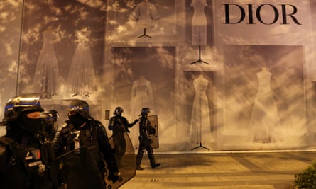 Police officers stand guard in front of the Dior building on the Champs Élysées in Paris