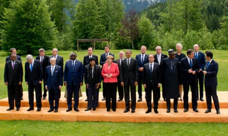 G7 leaders, including Angela Merkel (in pink jacket), and invitees line up for the traditional group photo at the end of the summit.