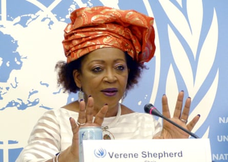 Verene Shepherd speaks during a news conference in Geneva in front of a blue and white UN logo. She is in her 60s and wears a large orange and gold head-wrapping.