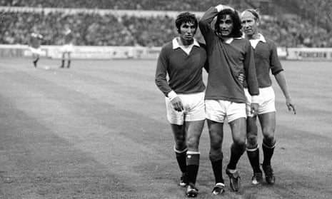 Tony Dunne helps George Best off the field against Chelsea at Stamford Bridge.