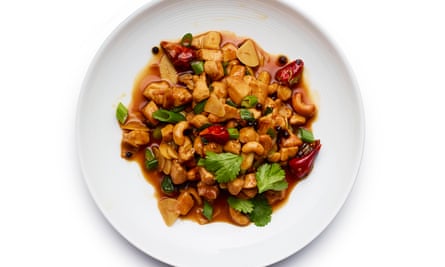 Close-up of kung pao chicken stir fry with cashew nuts on a white plate