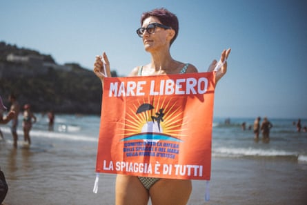 Manuela Salvi, member of the Mare Libero, pictured on the beach of Gaeta holding a placard