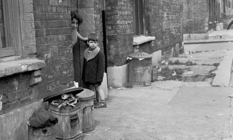 1950s. Small boy with mother in the doorway of run-down Victorian terraced house, in this historical picture by J Allan Cash.