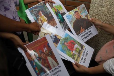 Relatives display photos of missing people with their names and identity numbers