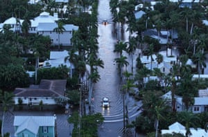 cars drive down a flood street
